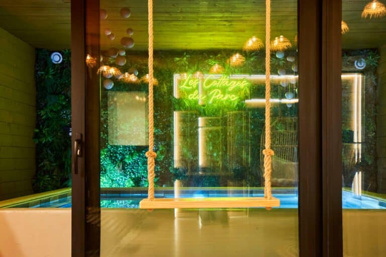 Balançoire face à la piscine privative et au mur végétal du Cottage Scandinave