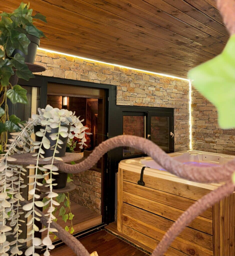 Spa privatif du cottage suédois avec mur en pierre et décoration boisée